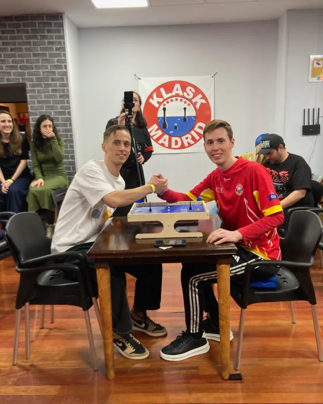 Dos jugadores se dan la mano sobre el tablero